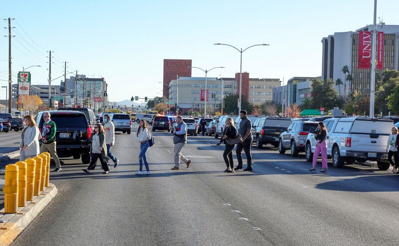 LAS VEGAS, NEVADA - DECEMBER 06: People cross Maryland Parkway as they are led off of the UNLV campus after a shooting on December 06, 2023 in Las Vegas, Nevada. According to Las Vegas Metro Police, a suspect is dead and multiple victims are reported after a shooting on the campus. (Photo by Ethan Miller/Getty Images)